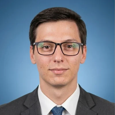 José Palacios Beortegui, con gafas y traje oscuro, sobre fondo azul